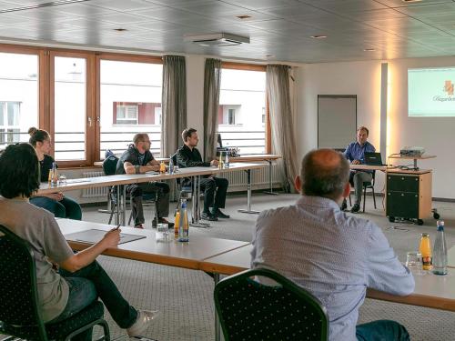 a group of people sitting at tables in a room at Hotel Begardenhof in Cologne