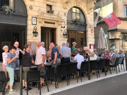 a group of people sitting at tables outside a building at Hotel de la Basilique in Paray-le-Monial