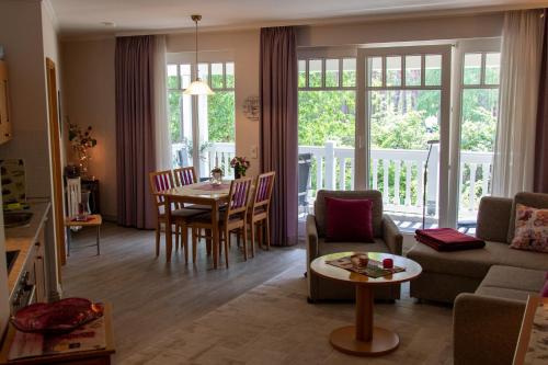 a living room with a couch and a table at Dünenpark in Binz für Eltern und Kind in Binz