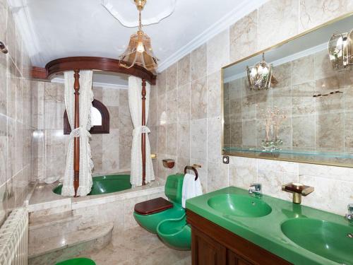 La salle de bains est pourvue d'un lavabo vert et d'une baignoire. dans l'établissement Casa de Can Riera con Piscina Comunitaria, à Moscari