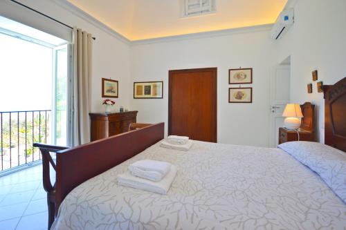 a bedroom with a large bed with two towels on it at Villa Azzurra in Conca dei Marini