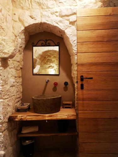 a bathroom with a sink in a stone wall at Borgo Sardedda Suites in Locorotondo