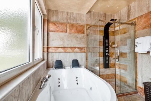 a bath tub in a bathroom with a window at Roof Top Villa Budva in Budva