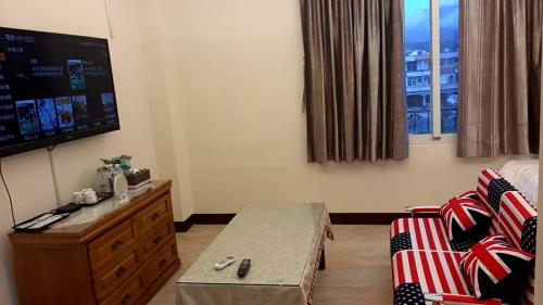 a living room with a couch and a tv at Chishang Daoxiang Hotel in Chishang