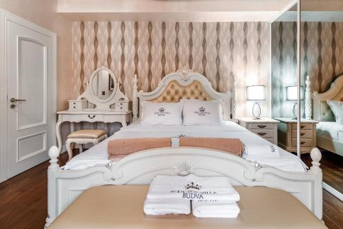 a bedroom with a large white bed with a mirror at Roof Top Villa Budva in Budva