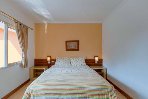 a bedroom with a bed with two night stands at Applewood B&B in Bogor