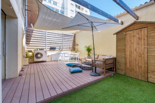 une terrasse avec un parasol, une table et des chaises dans l'établissement Bright 3br w AC and terrace near the train station in Marseille Welkeys, à Marseille