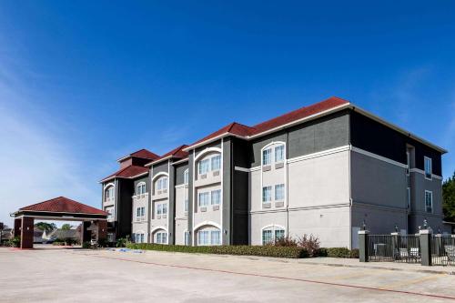 a large white and black building with a red roof at La Quinta by Wyndham Lumberton in Lumberton