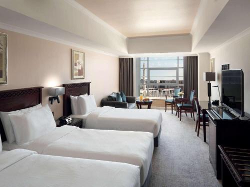 a hotel room with two beds and a television at Anwar Al Madinah Mövenpick in Al Madinah