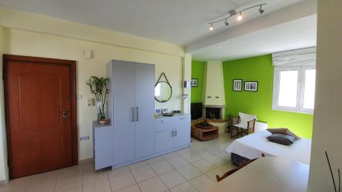 a bedroom with green walls and a bed and a mirror at Acropolis at your fingertips in Athens