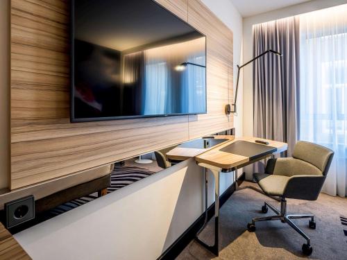 a room with a desk and a chair at Novotel Den Haag City Centre, fully renovated in The Hague