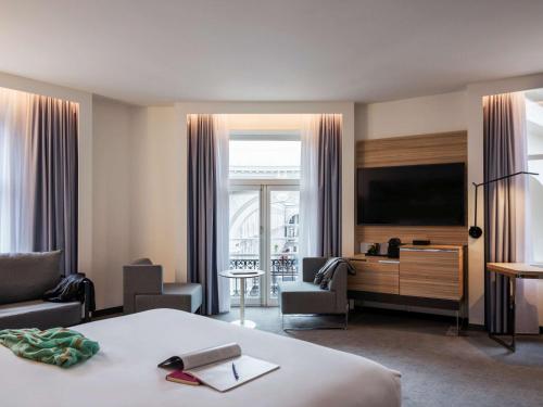 a hotel room with a bed and a large window at Novotel Den Haag City Centre, fully renovated in The Hague