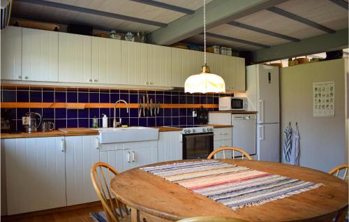 a kitchen with a wooden table and a kitchen with white cabinets at Lovely Home In Lammhult With Wifi in Lammhult