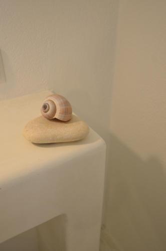 a snail sitting on top of a white table at Nufaro in Naxos Chora