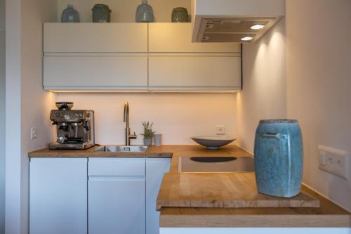 a kitchen with white cabinets and a counter with a sink at Ski-in Luxury Apartement in Center La Tzoumaz in La Tzoumaz