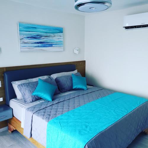a bedroom with a bed with blue pillows at Hotel Agua Dulce in Boca Chica