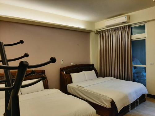 a hotel room with two beds and a window at Chishang Daoxiang Hotel in Chishang