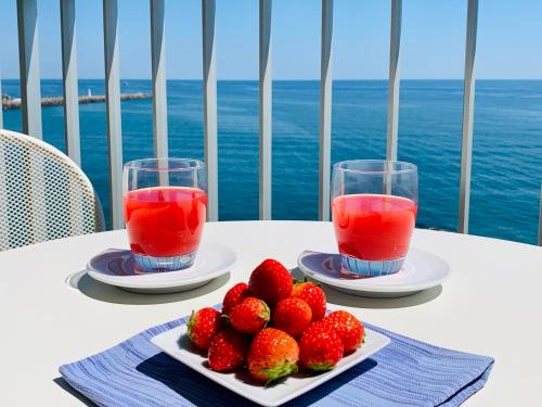 a table with strawberries and two glasses of juice at Hotel Corallo in Imperia