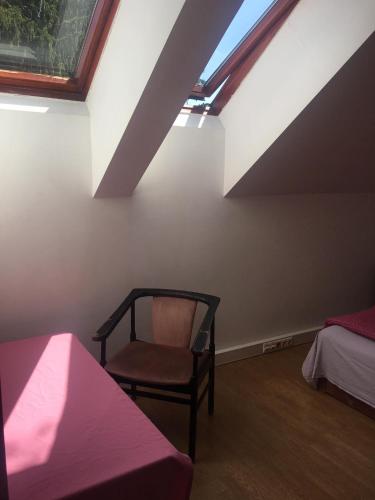 a attic room with a chair and a bed at Göncölház in Vác