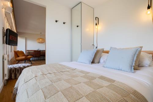 a bedroom with a large white bed with blue pillows at Ski-in Luxury Apartement in Center La Tzoumaz in La Tzoumaz