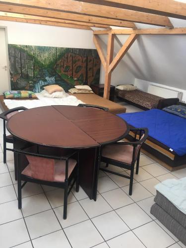 a table and chairs in a room with beds at Göncölház in Vác