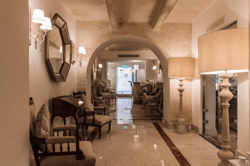 a hallway with chairs and a table in a building at Osborne Hotel in Valletta