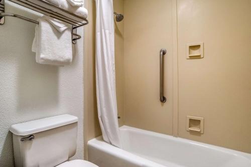 a small bathroom with a toilet and a shower at Clarion Inn Conference Center in Gonzales