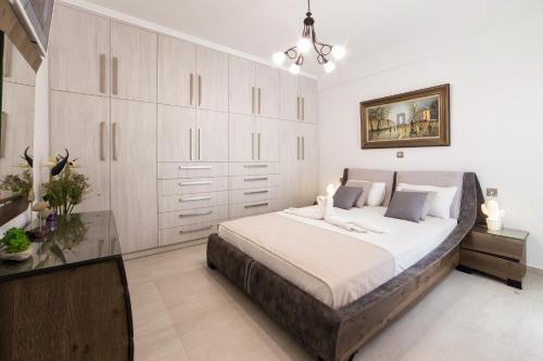 a bedroom with a large bed with white cabinets at Panos Villa Sunset View in Parikia