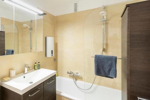 ein Bad mit einer Dusche, einem Waschbecken und einem Spiegel in der Unterkunft Petras Ammerseeblick in Herrsching am Ammersee