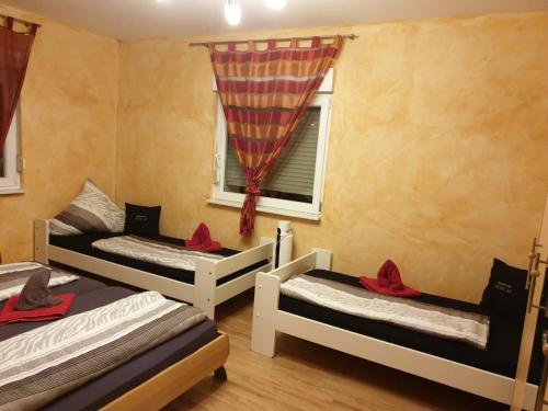a room with three beds and a window at Apartment Euro AS in Kappel-Grafenhausen