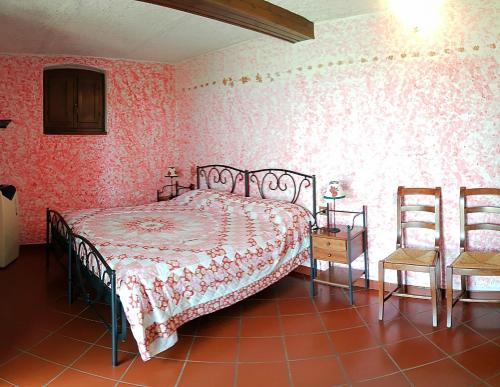 a bedroom with a bed and two chairs in it at Agriturismo Il Tondino in Tabiano
