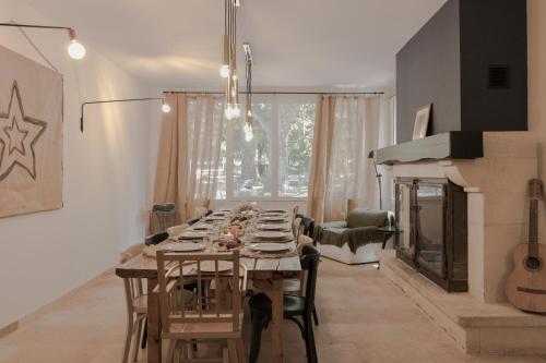 a dining room with a long table and a fireplace at Mas neuf de Romanin : Mas Provençal Familial in Saint-Rémy-de-Provence