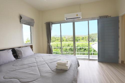 a bedroom with a bed with two towels on it at Baan Rabiengkao Hua Hin in Hua Hin