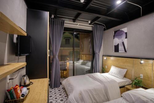 a bedroom with two beds and a television in it at THE NEST QUANG BINH in Dong Hoi