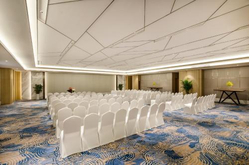 a room with rows of white chairs in it at Holiday Inn Nanjing Harbour by IHG in Nanjing