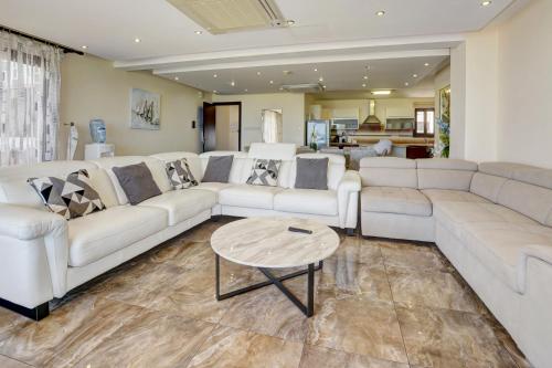 a large living room with white couches and a table at Seafront Protaras Villas in Protaras