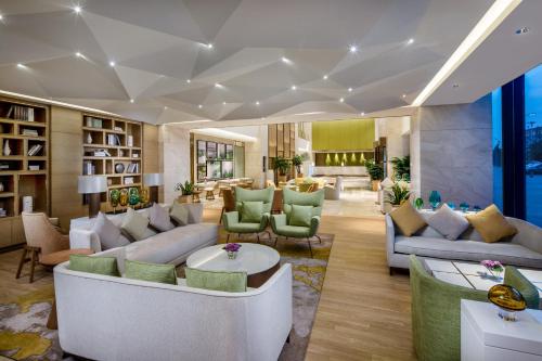 a large living room with couches and chairs at Holiday Inn Nanjing Harbour by IHG in Nanjing