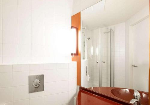 a bathroom with a red tub and a shower at City Hotel Budapest in Budapest