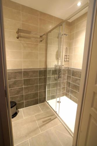 une douche avec une porte vitrée dans une salle de bain dans l'établissement ETOILE D'ISIS, Gites a la ferme, à Lavaur