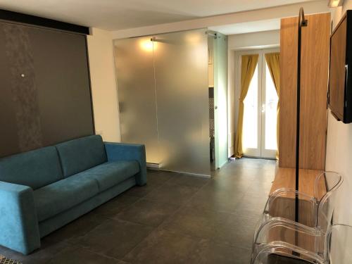 ein Wohnzimmer mit einem blauen Sofa und einem TV in der Unterkunft Alley House in Cefalú