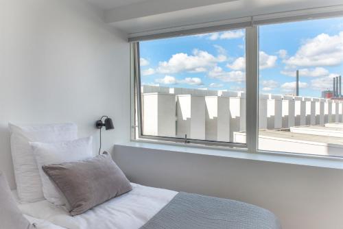 a bedroom with a bed and a large window at STAY Bryggen in Copenhagen
