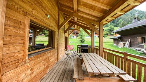 a wooden porch with a bench and a window at Le Ciste - Chalet - BO Immobilier- Châtel- remises sur les forfaits de skis Châtel ou Portes du soleil in La Chapelle-dʼAbondance