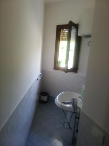 a bathroom with a sink and a window at Callipigia in Marsala