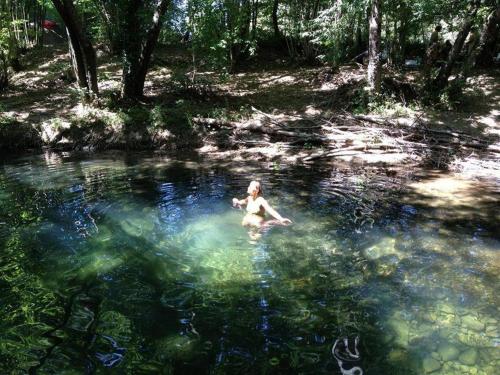 a woman swimming in a pool of water at La grotta nel borgo in Roccastrada