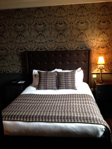 a bedroom with a large bed with a blanket at The Crown And Thistle, Abingdon in Abingdon