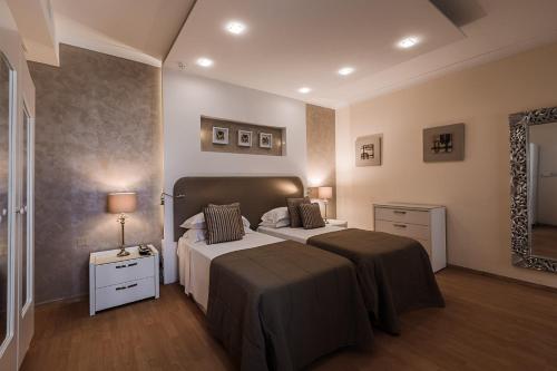 a bedroom with two beds and a mirror at Osborne Hotel in Valletta