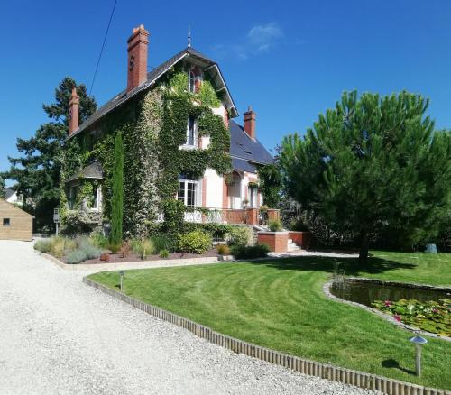 a house with ivy on the side of it at Villa Moya, dependance privée Piscine & Spa in Châteauneuf-sur-Loire