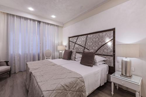 a bedroom with a large bed and a large window at Osborne Hotel in Valletta