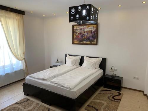 1 dormitorio con 1 cama grande con marco negro en CHIC CITY Rooms, en Sighişoara