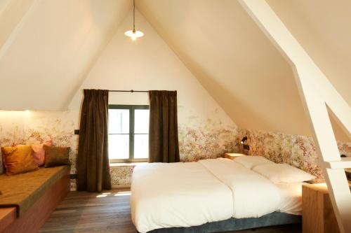 - une chambre avec un lit blanc et une fenêtre dans l'établissement Nonam Boutique Hotel Gent, à Gand